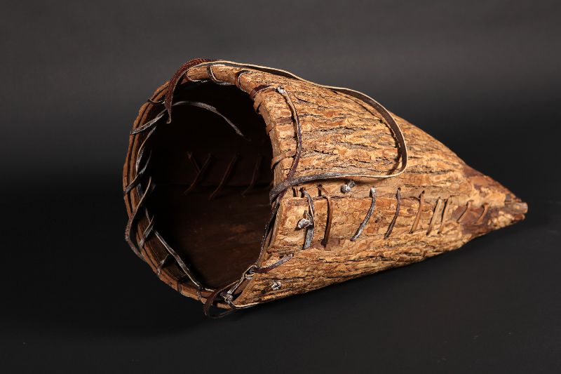 An elm bark portage basket, laid on its side.